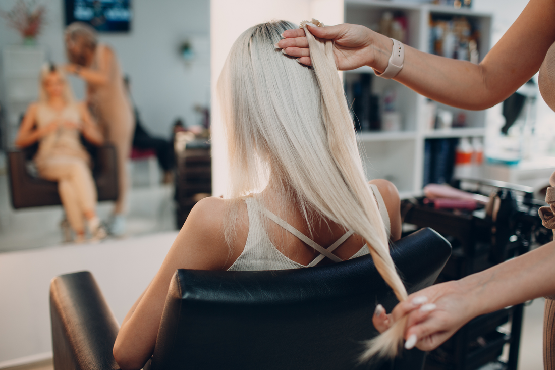 Stylists Amber Segovia and Crystal Kittrell expertly applies premium hair extensions to a client, enhancing length and volume for a natural, seamless look. Brilliant Gems Hair Studio is the new location for Beehive Hair Salon in Boerne, TX